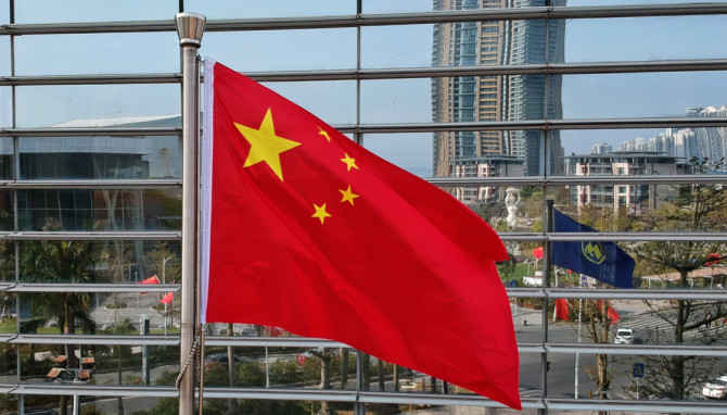 chinese flag in front of a high rise.