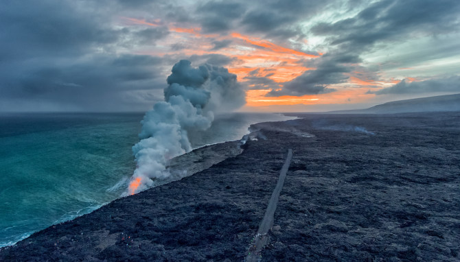 黄昏时火山喷发的岩浆流入大海