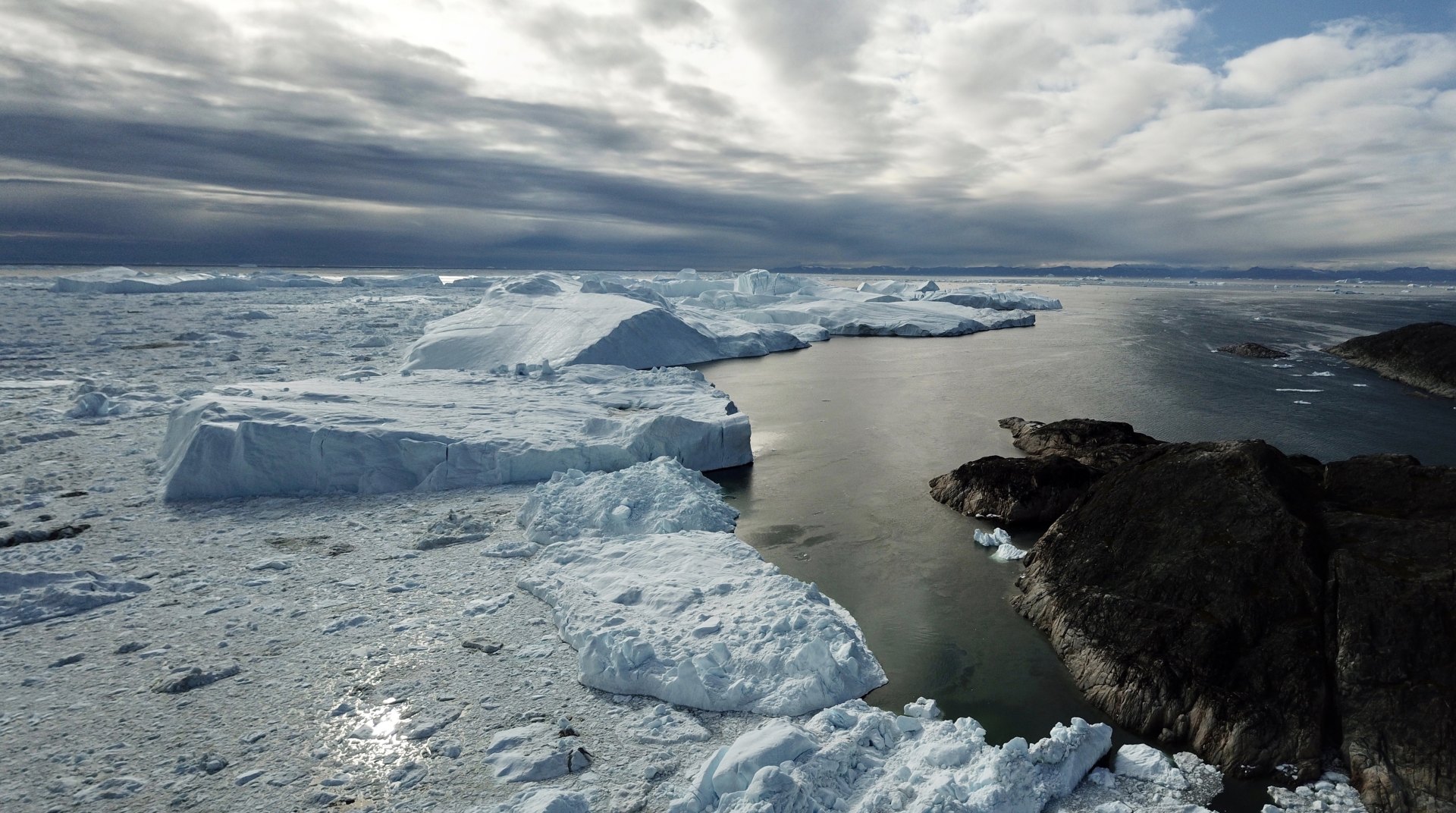 a fjord crossing icebergs in disko bay.